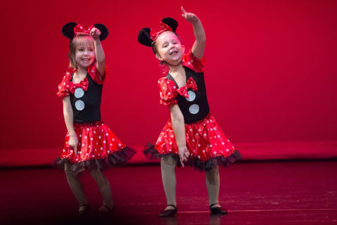 Two preschool girl dancers dressed in Mickey costume performing on red stage